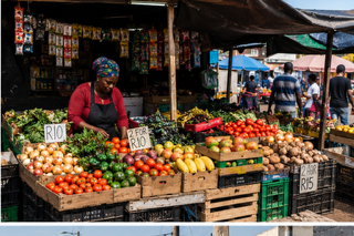 A community store owner at a fresh produce stall